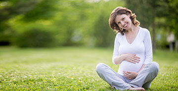 Donna incinta seduta prato